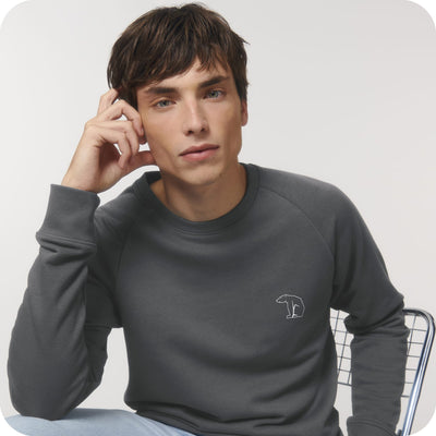 man looking into the camera wearing a grey organic cotton sweatshirt with a white bear logo on